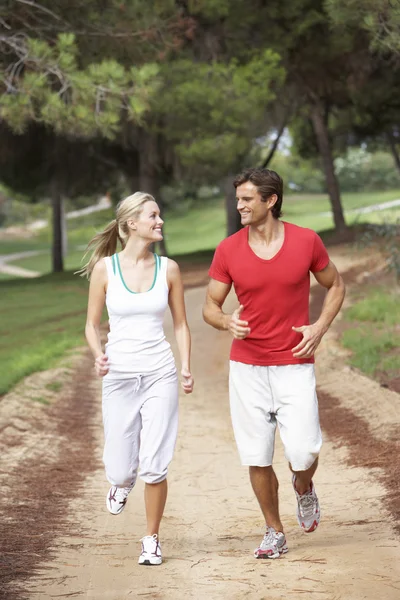 一对年轻夫妇在公园里奔跑 — 图库照片