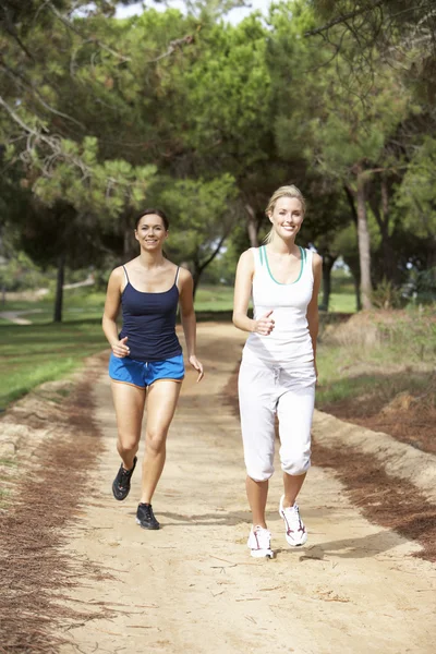 Две молодые женщины бегут в парке — стоковое фото