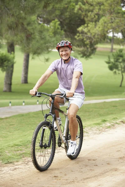 Homem sênior desfrutando de passeio de bicicleta no parque — Fotografia de Stock