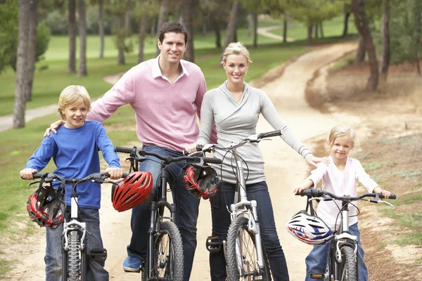 Familjen njuter av cykeltur i park — Stockfoto