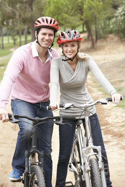 Couple riding bicycle in park — Stock Photo, Image