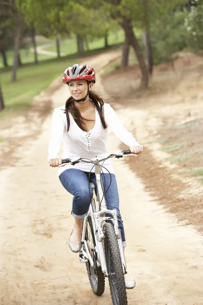 Woman riding bicycle in park — Stock Photo, Image