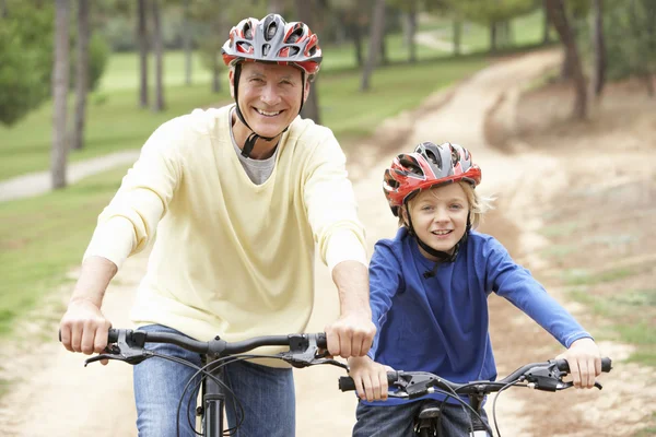 Dědeček a vnuk jedoucí na kole v parku — Stock fotografie