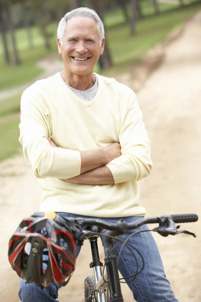 Idős férfi lovaglás kerékpár a parkban — Stock Fotó