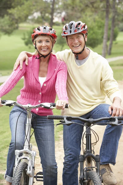 年配のカップル公園で自転車に乗って — ストック写真