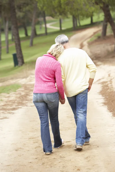 公園で散歩を楽しんでいる年配のカップル — ストック写真