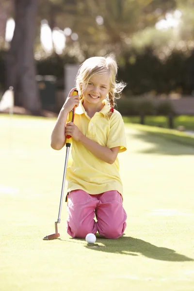 Młoda Dziewczyna Praktykujących Golfa Umieszczenie Zielono Zdjęcia Stockowe bez tantiem