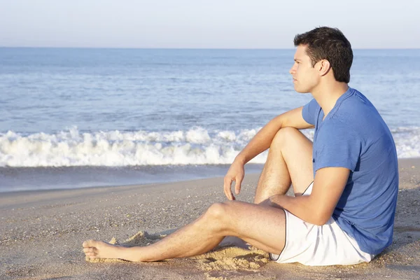 Mann sitzt entspannt am Strand — Stockfoto