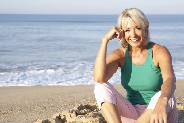 Senior mulher sentada na praia relaxante — Fotografia de Stock