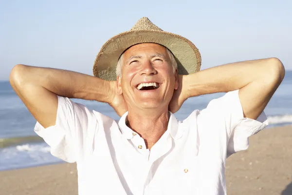 Senior man sitting on beach relaxing — Stock Photo, Image