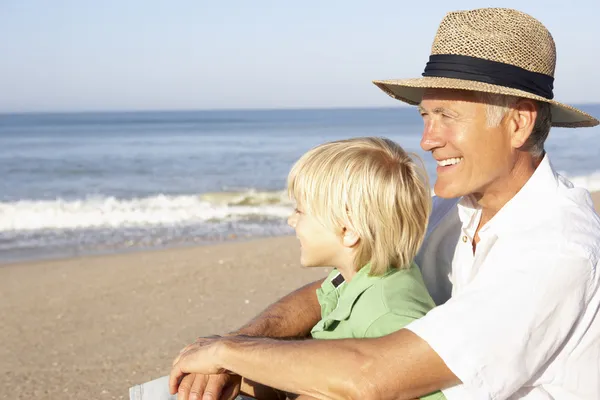 Grandfather with child on beach relaxing — Stock Photo, Image