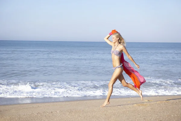 ผู้หญิงสาววิ่งบนชายหาด — ภาพถ่ายสต็อก