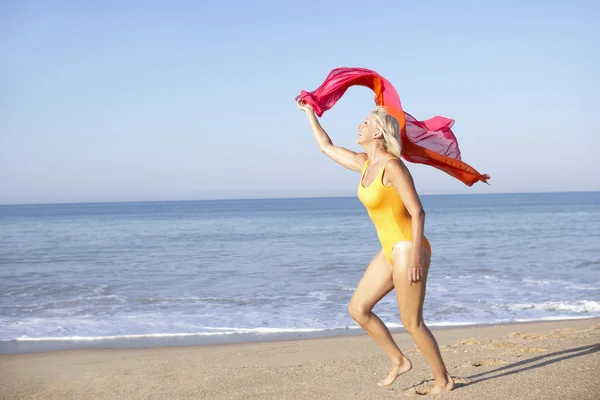 Donna anziana in esecuzione sulla spiaggia — Foto Stock