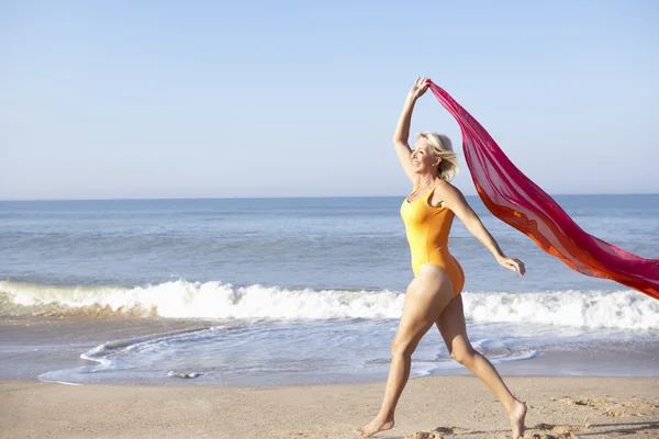 Mulher sênior andando na praia — Fotografia de Stock
