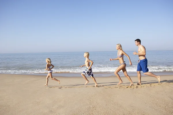 Młode rodziny działa na plaży — Zdjęcie stockowe