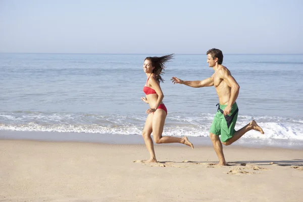 Молодая пара бегает по пляжу — стоковое фото