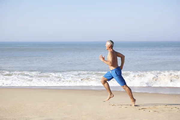 Senior man running on beach — Stok fotoğraf