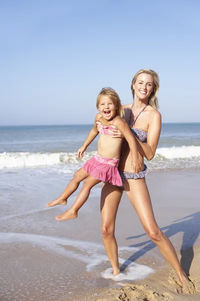 ビーチに若い女の子と遊ぶ母 — ストック写真