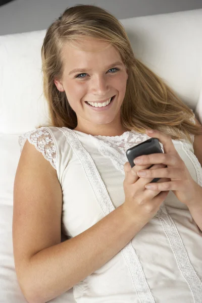 Студийный портрет девочки-подростка с мобильным телефоном — стоковое фото