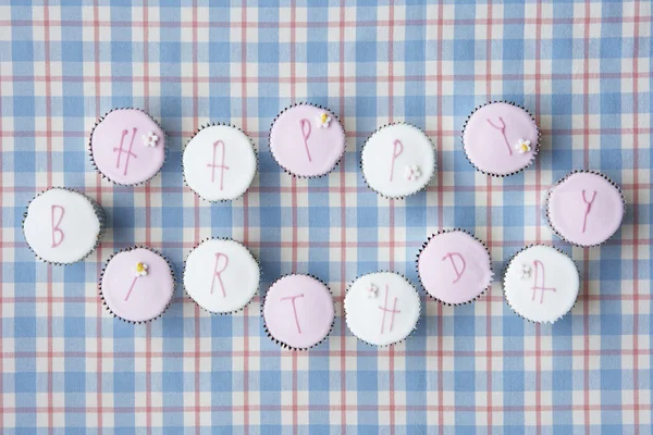 Cupcakes deletrear feliz cumpleaños —  Fotos de Stock