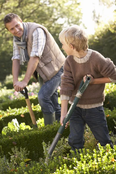 Bahçede çalışan çocuk ile genç adam — Stok fotoğraf