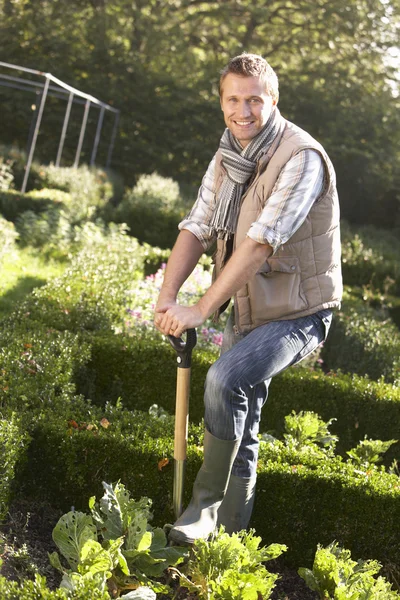 Ung mann arbeider i hagen – stockfoto