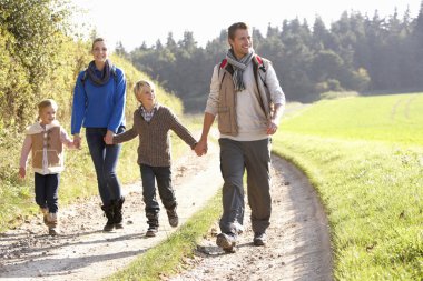 Young family walking in park clipart