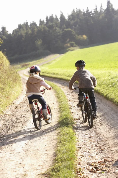 Deux jeunes enfants font du vélo dans le parc — Photo