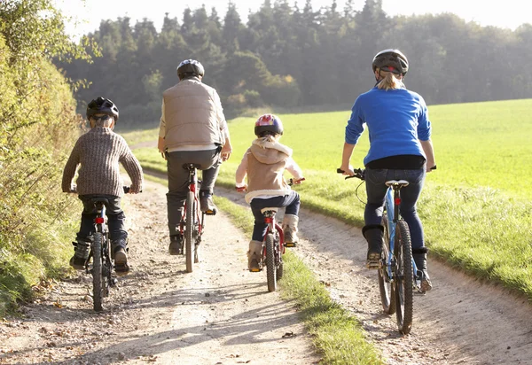Unga föräldrar med barn cykla i park — Stockfoto
