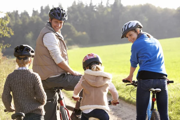 Jovens pais com crianças andam de bicicleta no parque — Fotografia de Stock