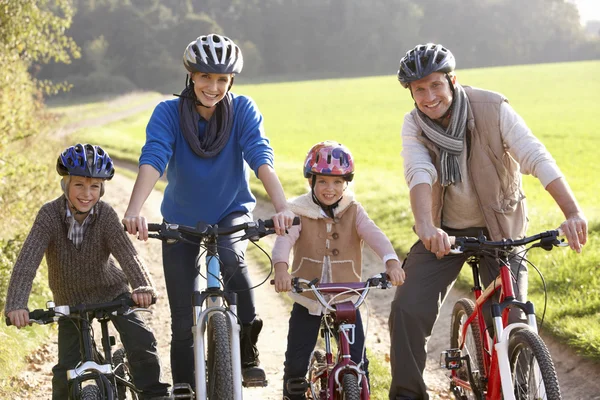 Jeune famille pose avec des vélos dans le parc — Photo