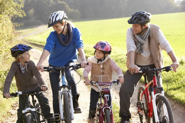 Young family pose with bikes in park — Stock Photo, Image