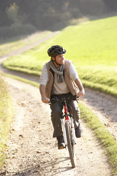 Giovane uomo cavalca la sua bicicletta nel parco — Foto Stock