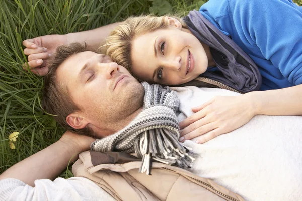 年轻的夫妇一起躺在草地上 — 图库照片