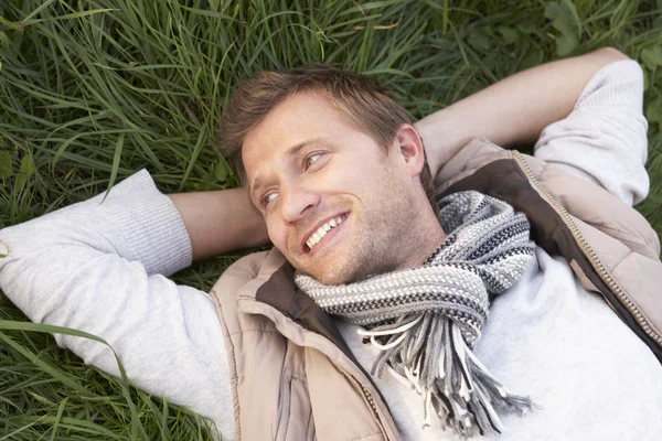 一个人躺在草地上的年轻人 — 图库照片