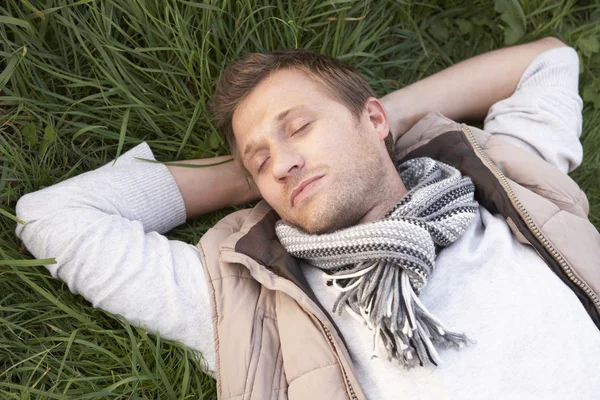 Jonge man slapen alleen op gras — Stockfoto