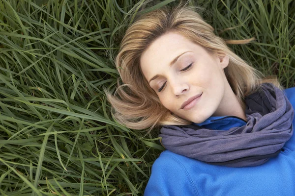 Mujer joven durmiendo sola en la hierba — Foto de Stock