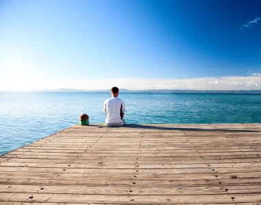 Young man relax watch on ocean clipart