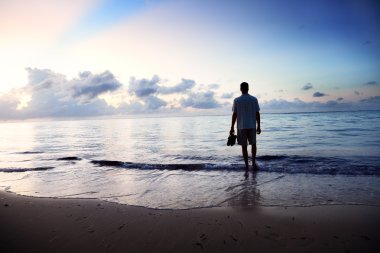 Young man and sunset on sea clipart