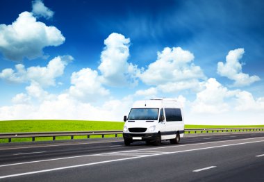 Van on road and perfect summer day clipart