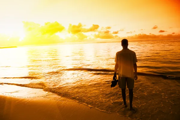 Genç adam ve Karayip Denizi kıyısında günbatımı — Stok fotoğraf