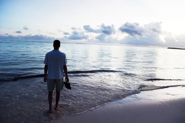 Genç adam ve Karayip Denizi kıyısında günbatımı — Stok fotoğraf