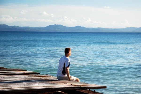 Giovane uomo rilassarsi guardare sull'oceano — Foto Stock