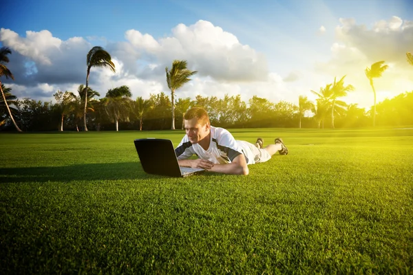 Young man whith notebook on the green field — Stock Photo, Image