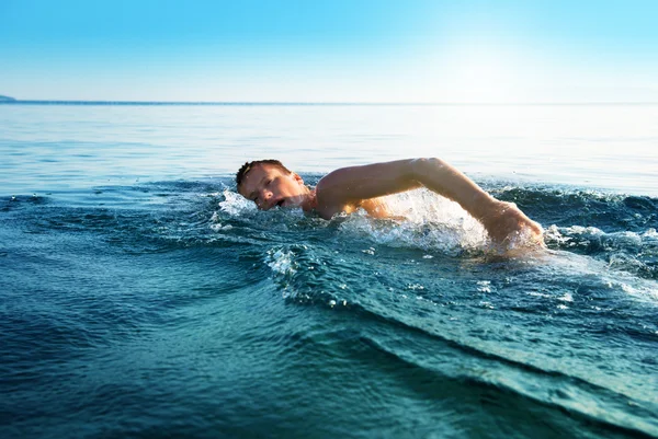Schwimmender junger Mann — Stockfoto