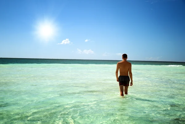 Jeune homme marchant dans la mer des Caraïbes — Photo