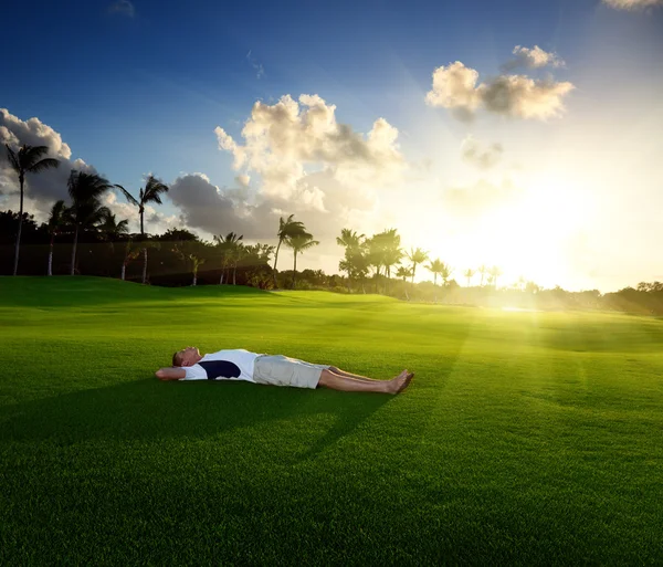 年轻男子在绿色草地上放松 — 图库照片
