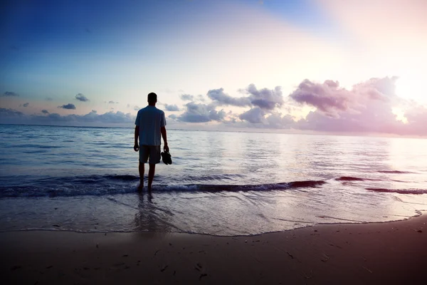 Νεαρός άνδρας και το ηλιοβασίλεμα στη θάλασσα — Φωτογραφία Αρχείου