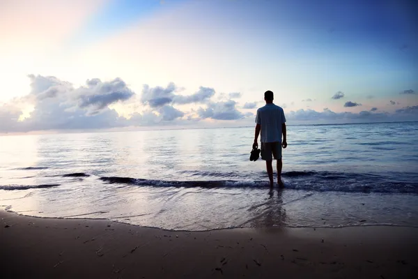 Jonge man en zonsondergang op zee — Stockfoto