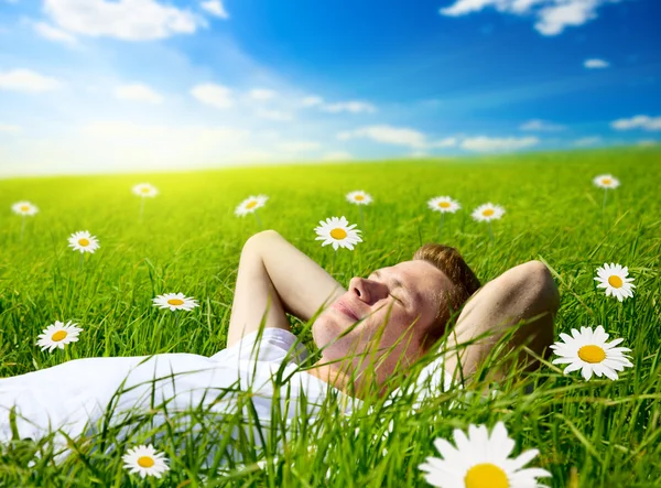 Young man in flowers — Stock Photo, Image